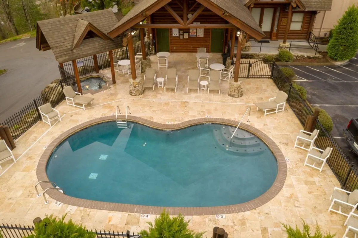 A sparkling outdoor swimming pool is surrounded by lounge chairs and a covered gazebo, evoking fun-filled days and relaxing moments for guests. The setup suggests an amenity that families can enjoy together after exploring local attractions, with ample space for both play and relaxation.